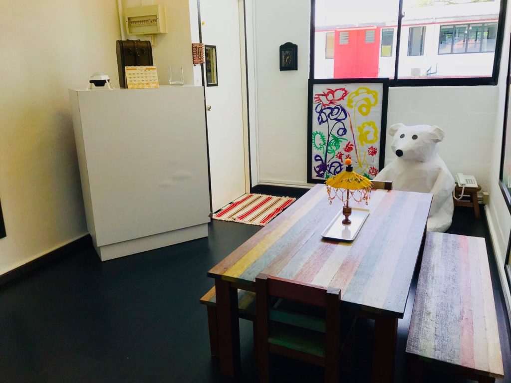 Artwork by Tambalog alumni adorn the walls of the dining area in the Ladder room. Warm Paws, the papier-mache school mascot, watches the children from his comfortable corner. (Credit: Tambalog)