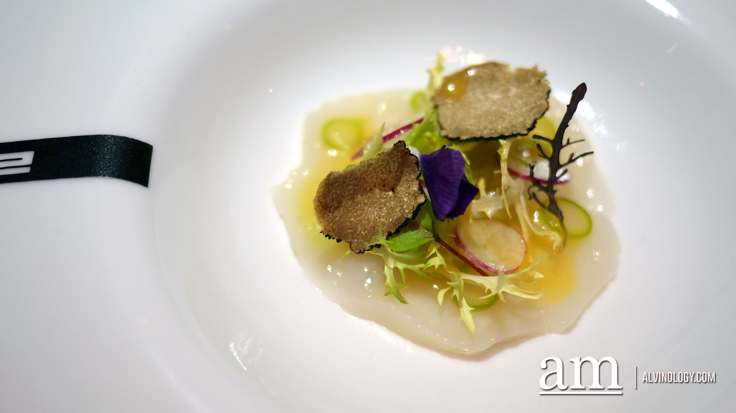 Scallops carpaccio served with black truffles, raw asparagus in olive oil and lemon juice and truffle essence