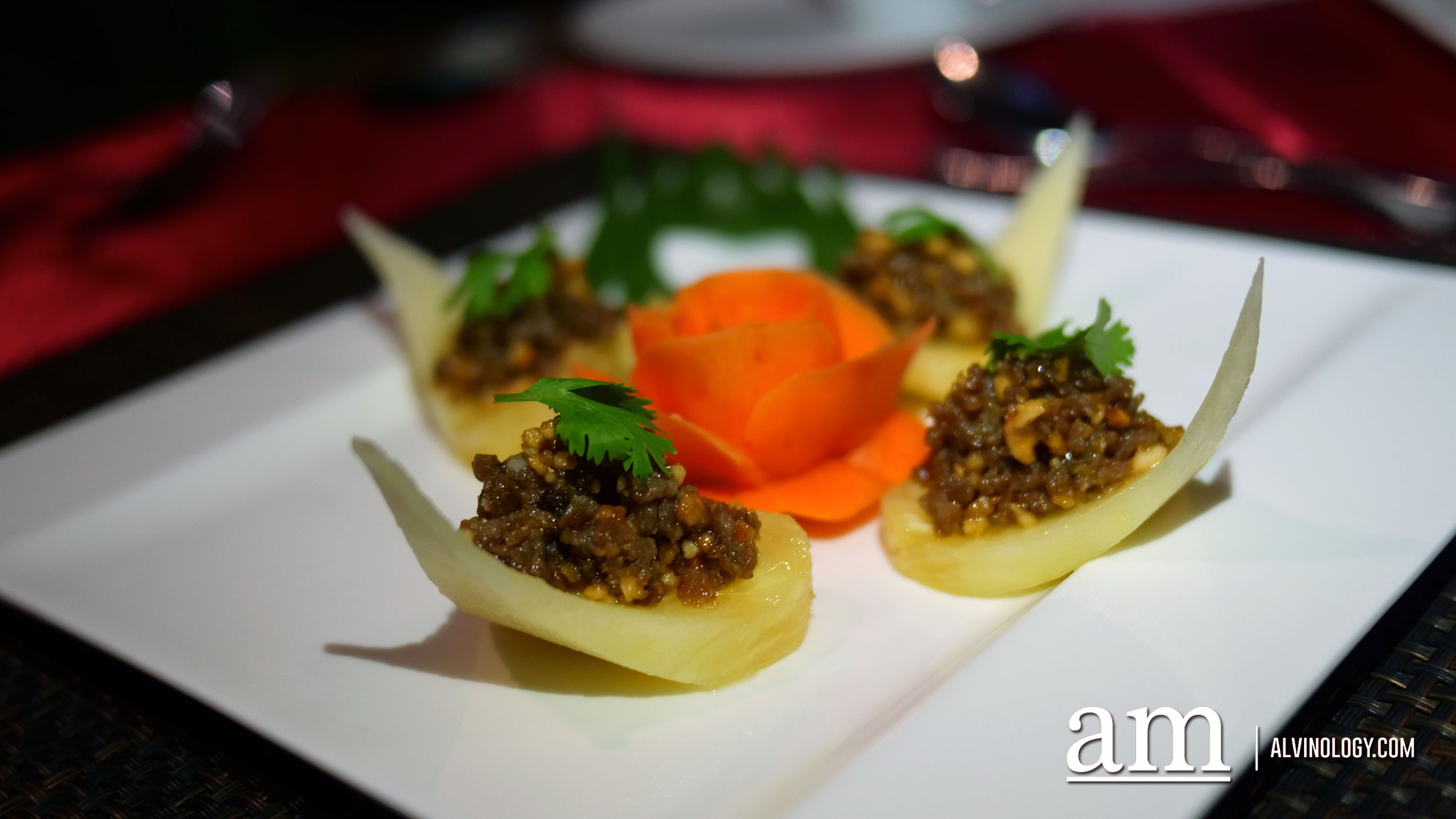 Amuse Bouche - Minced pork and prawns stir fried in a cilantro paste, seasoned with palm sugar and peanuts, served on a pineapple bite