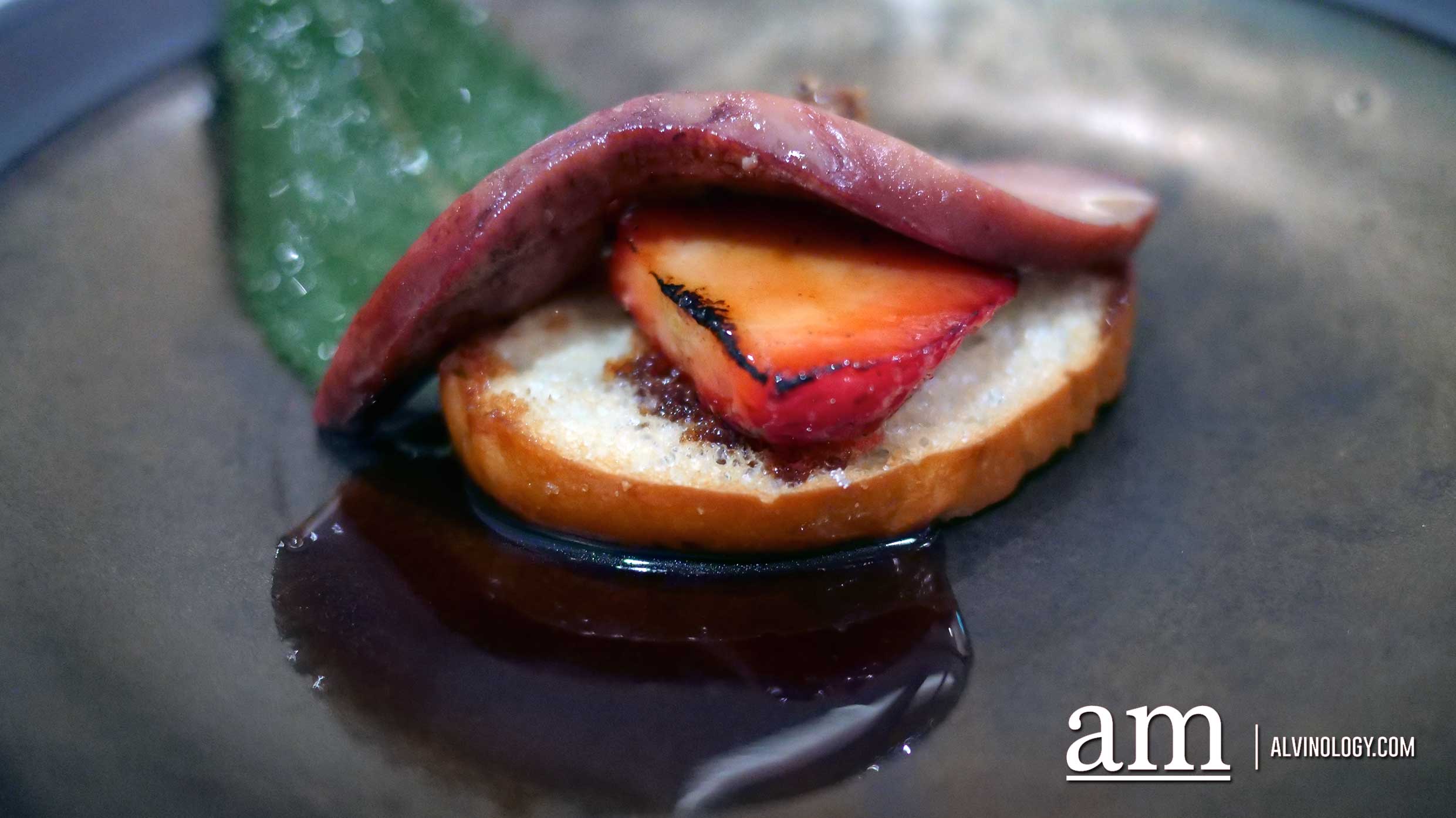 The strawberry sandwiched between the seared foie gras and bread 