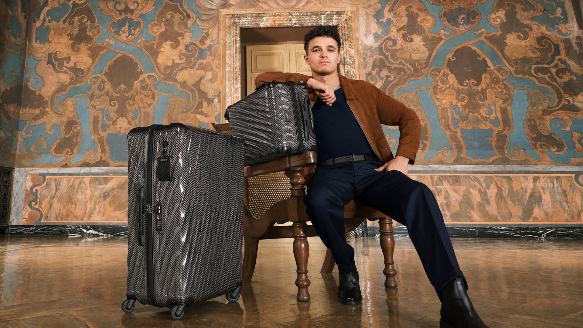 TUMI Celebrates The New 19 Degree Lite Collection With Campaign Starring Global Ambassador, Lando Norris Lando Norris with 19 Degree Lite International Carry-On and Extended Trip Packing Case in Black Graphite