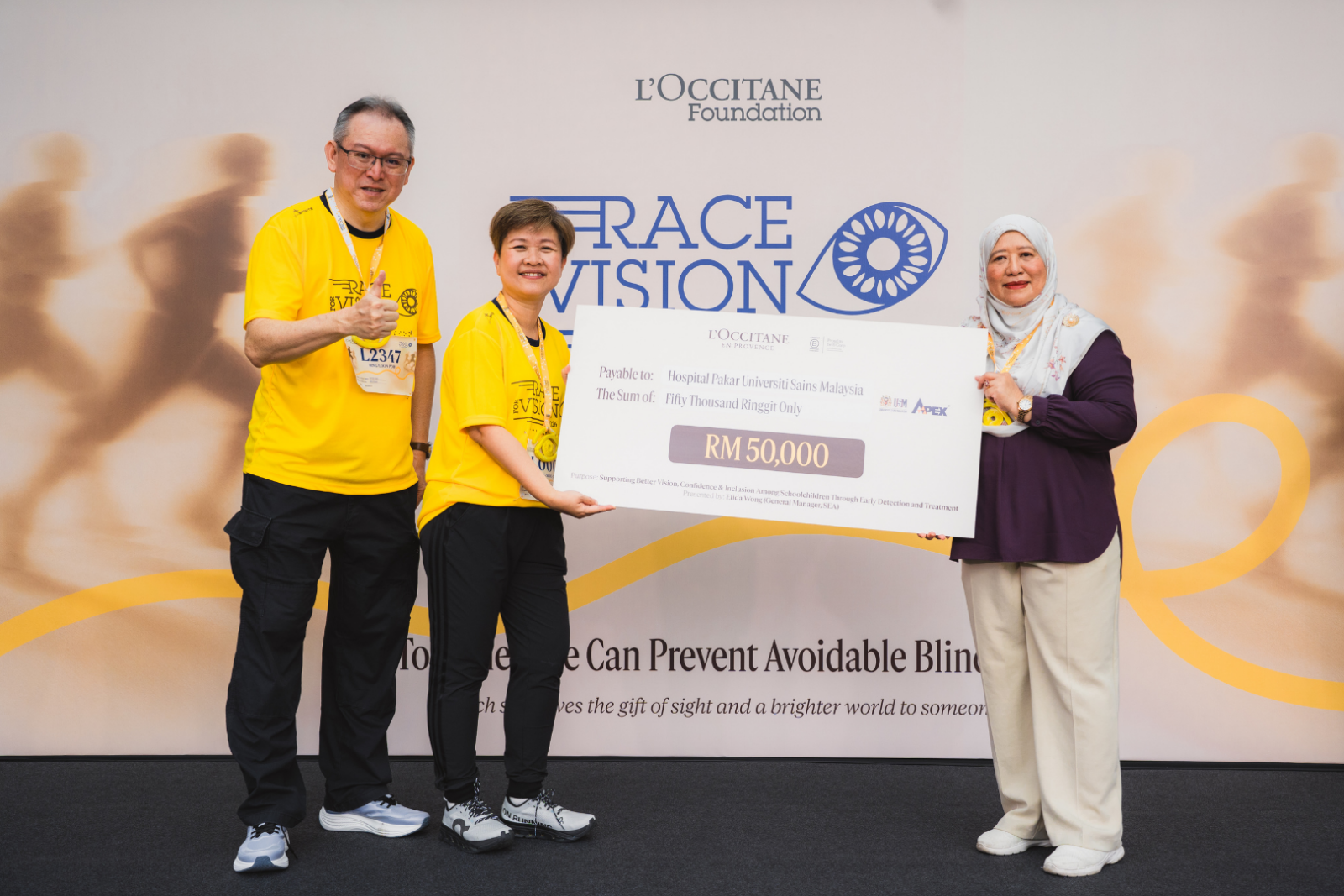 Mock cheque presentation by L'OCCITANE Malaysia's top management team:Mr Sing Loonpoh, Deputy General Manager of L'OCCITANE Malaysia (left), and Ms Elida Wong, General Manager of L'OCCITANE SEA (centre), with Professor Dr Shatriah Ismail, Deputy Director of Hospital Pakar Universiti Sains Malaysia (right).